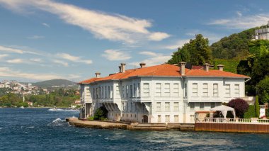 İstanbul ve Türkiye 'de yaz günlerinde geleneksel evler ve sık ağaçlarla, Asya yakasının yeşil dağlarının İstanbul Boğazı' ndan görüntüsü