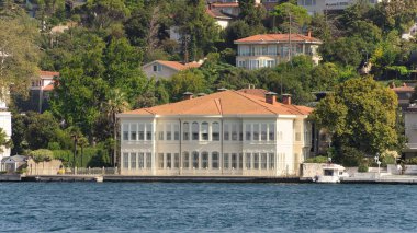 İstanbul ve Türkiye 'de yaz günlerinde geleneksel evler ve sık ağaçlarla, Asya yakasının yeşil dağlarının İstanbul Boğazı' ndan görüntüsü