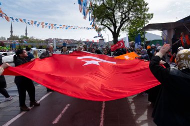 İstanbul, Türkiye - 3 Mayıs 2023: AK Parti destekçileri 2023 seçimlerinde Üskudar Mahallesi 'nde AK Parti çadırının önünde büyük bir Türk bayrağı sallıyorlar