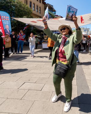 İstanbul, Türkiye - 13 Mayıs 2023: 2023 seçimlerinde Ortakoy Mahallesi 'ndeki Cumhuriyet Halk Partisi büfesi önünde seçim kampanyası broşürleri tutan kadın dansçıları