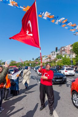 İstanbul, Türkiye - 13 Mayıs 2023: AK Parti destekçisi 2023 seçimlerinde Uskudar Mahallesi 'nde büyük bir Türk bayrağı sallıyor