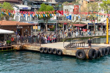 İstanbul, Türkiye - 8 Mayıs 2023: İstanbul Boğazı, Ortakoy Feribot Terminali feribot bekleyen yolcular ve arka planda kalabalık Ortakoy Meydanı