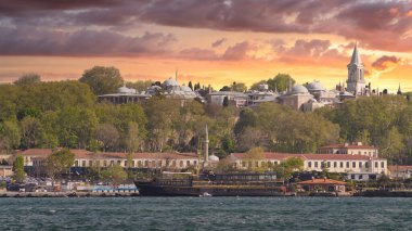 Günbatımından önce İstanbul, Türkiye 'de Galataport' tan İstanbul 'a doğru yelkenli feribot ve Topkapı Sarayı' na bakan Boğaz manzarası