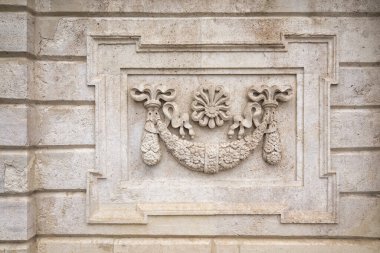 Dolmabahçe Sarayı 'nın eski taş duvarının desenli arka planında oyulmuş çiçek desenli süsler ve oyulmuş detaylar, Beşiktaş ilçesi, İstanbul, Türkiye