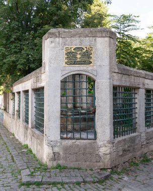 Cobblestone alley at Eyup Sultan Cemetery, with stone fence built of stone bricks and wrought iron windows, located near Eyup Sultan Mosque at Eyup district, Golden Horn, Istanbul, Turkey