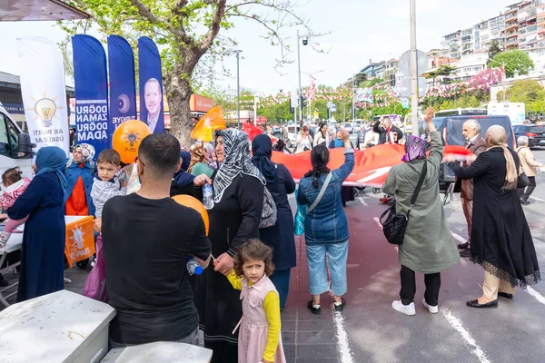 İstanbul, Türkiye - 3 Mayıs 2023: AK Parti destekçileri 2023 seçimlerinde Uskudar Mahallesi 'nde AK Parti çadırının önünde Türk bayrağı sallıyorlar