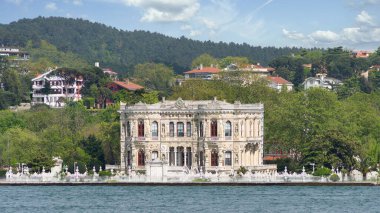 Kucuksu Pavyonu 'nun Boğazı' ndan manzara, nam-ı diğer Kucuksu Kasri, İstanbul, Türkiye 'nin Asya yakasında güzel bir saray, arka planda yeşil dağlar bulunuyor.