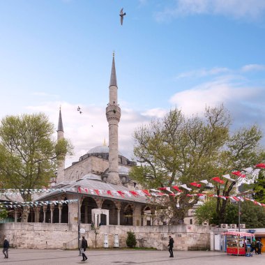 İstanbul, Türkiye - 5 Mayıs 2023: Mihrimah Sultan Camii, Uskudar, Asya yakasında. Cami bereketli ağaçlarla ve mavi gökyüzü ile renkli seçim kampanyalarıyla çevrili.