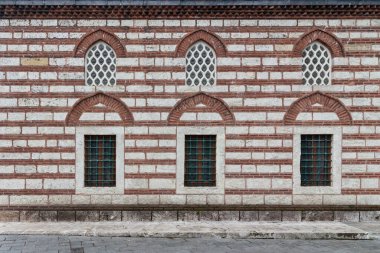 İstanbul 'un Uskudar kentindeki Selman Ağa Camii' nin dış duvarı. Duvar kırmızı tuğladan yapılmıştır ve iki sıra kemerli delinmiş sıva ve işlenmiş demir pencereleri vardır.