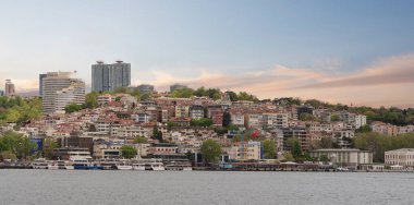 İstanbul Boğazı 'nın Avrupa yakası, İstanbul, Türkiye, su üzerinde yüzen bir feribot ve arka planda şehir silüeti. Gökyüzü açık ve su sakin.