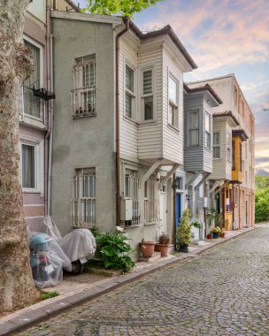 Kuzguncuk Mahallesi, Uskudar İlçesi, İstanbul, Türkiye 'de geleneksel renkli ahşap evlere sahip kaldırım taşı sokak
