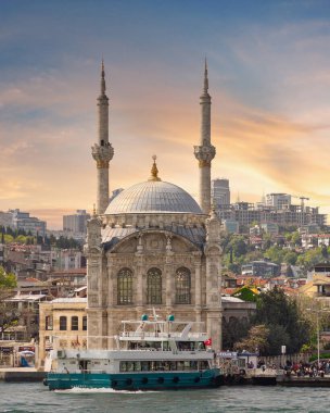 İstanbul, Türkiye - 8 Mayıs 2023: Ortakoy Camii 'ne tepeden bakan Boğaz manzarası, ya da Ortakoy Camii, nam-ı diğer Buyuk Mecidiye Camii, Ortakoy iskelesi meydanında gün batımından önce feribot ile geziyor.