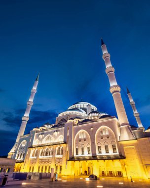İstanbul 'un Uskudar ilçesindeki Camlica Camii veya Buyuk Camlica Camii, gece karanlığında masmavi bir gökyüzüne doğru parladı. Minareler ve kubbeler altın ışıkla yıkanır ve büyülü bir sahne yaratır.