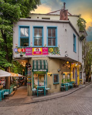 İstanbul, Türkiye - 9 Mayıs 2023: Kuzguncuk Mahallesi 'nde bir kaldırım taşları geçidinde rahat bir kafe. Cafe 'de müşterilerin dinlendiği ve mahallenin atmosferinin tadını çıkardığı birkaç masa ve sandalye var.