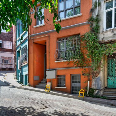 Eski Balat ilçesinde eski güzel turuncu boyalı evi olan kaldırım taşı sokak, bir yaz günü, İstanbul, Türkiye