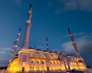 İstanbul 'un Uskudar ilçesindeki Camlica Camii veya Buyuk Camlica Camii, geceleyin mavi gökyüzüne karşı parladı. Minareler ve kubbeler altın ışıkla yıkanır ve büyülü bir sahne yaratır.