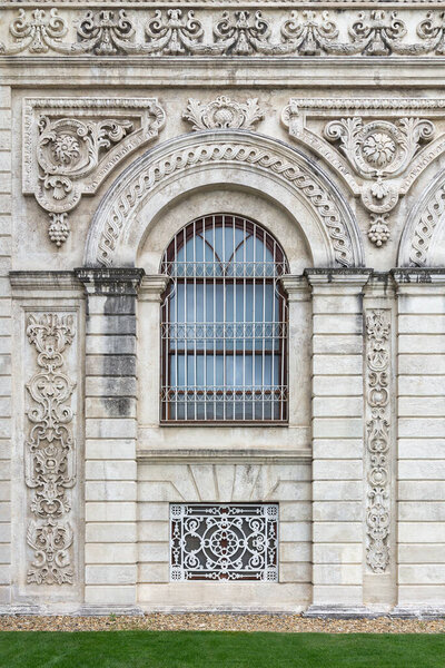 Side wall at Dolmabahce Palace, with arched sash window. Palace located in Besiktas district on the European coast of the Bosporus, Istanbul, Turkey