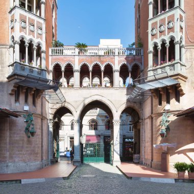 İstanbul, Türkiye - 13 Mayıs 2023: İki Venedik Neo-Gotik tarzı kırmızı tuğla Padua Kilisesi 'nin St. Anthony avlusundaki kemerli köprüye bağlı beş katlı bina