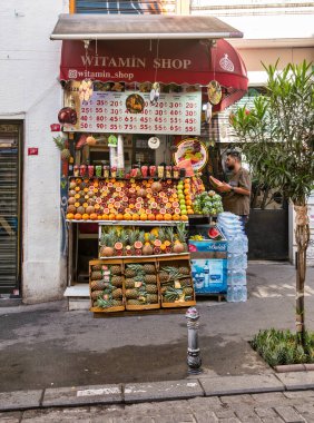 İstanbul, Türkiye - 13 Mayıs 2023: Istiklal Caddesi 'nde portakal, nar, ananas, karpuz, greyfurt ve muz gibi taze meyvelerle dolup taşan meyve standı ve meyve suyu barı