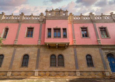 Sıcak gün batımı ışığı Prens Naguib Sarayı 'nı hafif bir parıltıyla yıkar. Karmaşık Mamluk mimarisini, Kahire' yi, Mısır 'ı aydınlatır.