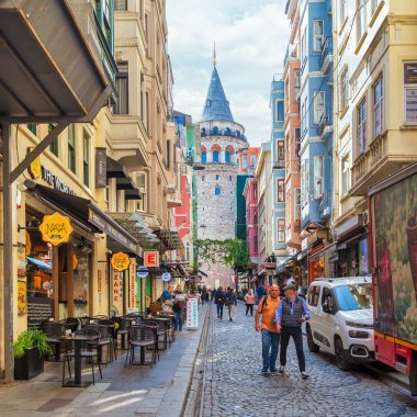 İstanbul, Türkiye - 13 Mayıs 2023: Dar ve atmosferik kaldırım taşlarından alınan popüler turizm merkezi Galata Kulesi Buyuk Hendek Caddesi