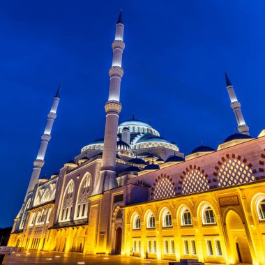 İstanbul 'un Uskudar ilçesindeki Camlica Camii veya Buyuk Camlica Camii, gece karanlığında masmavi bir gökyüzüne doğru parladı. Minareler ve kubbeler altın ışıkla yıkanır ve büyülü bir sahne yaratır.
