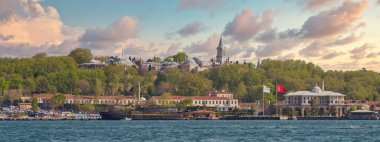 Günbatımından önce İstanbul, Türkiye 'de Galataport' tan İstanbul 'a doğru yelkenli feribot ve Topkapı Sarayı' na bakan Boğaz manzarası