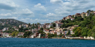 View from the sea of the green mountains of the Europian side of Bosphorus strait, with traditional houses and dense trees in a summer day, Istanbul, Turkey