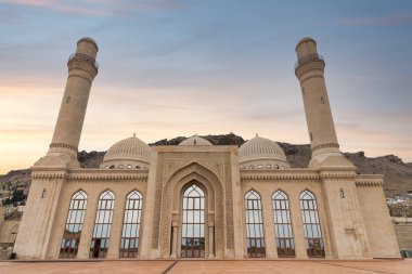 The Bibi-Heybat Mosque stands at sunset in Baku, Azerbaijan. The mosques domes, minarets, and intricate architectural details are prominently displayed against the twilight sky clipart