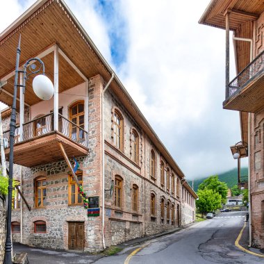 Azerbaycan 'ın Sheki kentindeki dar bir sokakta bulunan ahşap balkonlu geleneksel taş tuğlaların manzarası.