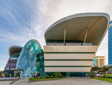 Bakü, Azerbaycan - 10 Mayıs 2024: Güneşli bir günde, üzerinde açık mavi gökyüzü bulunan Park Bulvar Alışveriş Merkezi 'nin modern tasarımına çok az insan yaklaşır
