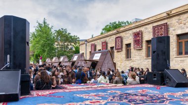 Bakü, Azerbaycan - 5 Mayıs 2024: Azerbaycan Ulusal Halı Festivali 'nde bir konser için kalabalık toplandı. Etkinlik Eski Şehir 'de, ya da Icherisheher' da, tarihi duvarlarla çevrili kentte gerçekleşiyor.