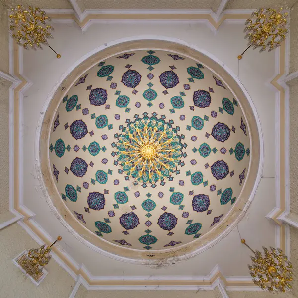 Stock image A view of the ornate ceiling inside the Goy Imam Mosque in Ganja, Azerbaijan. The dome is adorned with intricate geometric patterns in shades of blue, green, and gold