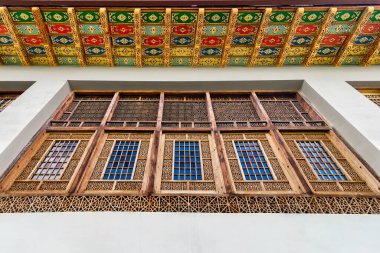Shaki, Azerbaycan 'daki Shakikhanovs Sarayı' nın karmaşık ahşap penceresi renkli desenli bir tavan tarafından çerçevelenmiş.