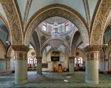 Interior shot of the Icherisheher Juma mosque in Old Town, Baku, Azerbaijan, featuring a grand chandelier and ornate arches clipart