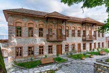 Shaki Khans Cami Kompleksi 'nin dış görünüşü, Azerbaycan' ın Shaki kentindeki tarihi bir bina. Binada taş duvarlar, ahşap balkonlar ve geleneksel mimari ayrıntılar yer alıyor..