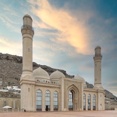 Bakü, Azerbaycan 'daki Bibi-Heybat Camii minareler, kubbeler ve karmaşık ayrıntılarla İslam mimarisini sergiliyor. Tepelere karşı koyunca, gün batımına karşı duruyor.