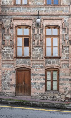 A well-preserved building features unique stonework and ornate windows, showcasing architectural beauty in a charming urban setting clipart