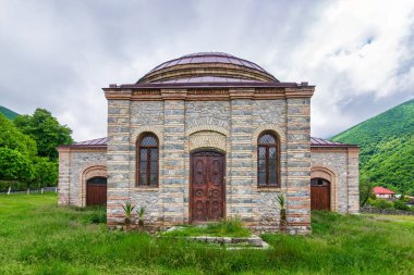 Üç Aziz Kilisesi, ya da Yuvarlak Tapınak, Shaki, Azerbaycan 'da yemyeşil ve dağlarla çevrili.