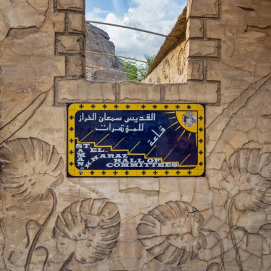 St. Samaan El Kharaz Konferans Salonu 'nun giriş tabelasında süslü taş oymalar ve canlı renkler yer alıyor, ziyaretçiler davet ediliyor, Saint Samaan' daki Tanner Manastırı, Kahire, Mısır