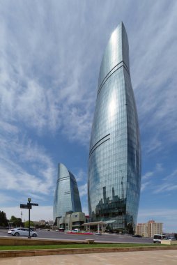 Bakü, Azerbaycan - 6 Mayıs 2024: Yeşil ve modern mimari ile çevrili Alev Kuleleri, şehrin ufuk çizgisini gözler önüne sererek görkemli bir şekilde yükseliyor