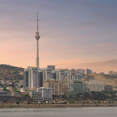Bakü TV Kulesi, Azerbaycan 'ın başkenti Bakü' ye çökerken Hazar Denizi 'nin arka planına karşı çağdaş yüksek binaların yanında yükseliyor.