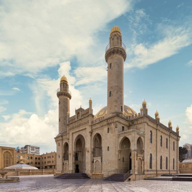 View of the majestic Taza Pir Mosque in Baku, Azerbaijan showcases intricate architecture with twin minarets against a peaceful blue clear sky clipart