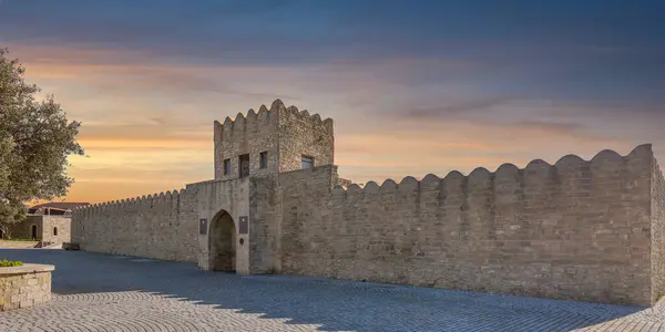 stock image External facade of the Ateshgah Fire Temple in Baku, Azerbaijan, a historic Zoroastrian temple. The stone structure features a stone fence, an arched doorway and a tower with door and small windows