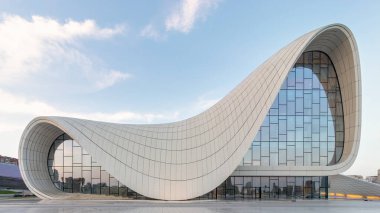 Azerbaycan 'ın Bakü kentindeki ikonik Heydar Aliyev Merkezi, mavi gökyüzüne karşı çağdaş mimariyi akıcı, dalga benzeri tasarımıyla sergiliyor. Merhum mimar Zaha Hadid tarafından tasarlanan bina. 