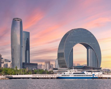 Şaşırtıcı Hilal Geliştirme Projesi, Ufuk çizgilerinin cazibesini artıran canlı bir günbatımıyla aydınlatılan Azerbaycan 'daki Baküs Hazar Denizi kıyısında kendine özgü bir mimariye sahip.