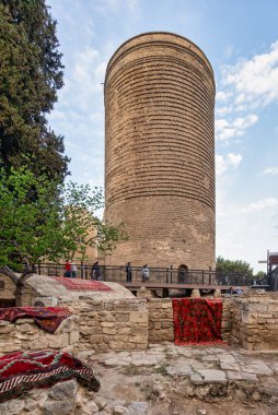 Baku, Azerbaijan - May 4, 2024: Visitors gather around Maidan Tower in Icherisheher, Baku, as vibrant carpets are displayed for the first National Carpet Festival of Azerbaijan clipart