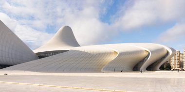 Azerbaycan 'ın Bakü kentindeki Heydar Aliyev Merkezi, bulutlu bir gökyüzüne karşı çağdaş mimarinin akıcı ve dalgalardan esinlenilmiş tasarımıyla örnek teşkil ediyor. Bu bina mimar Zaha Hadid tarafından tasarlandı.