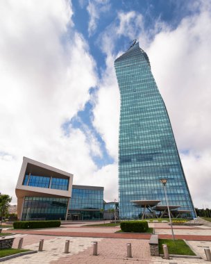 Bakü, Azerbaycan 'da etkileyici bir cam gökdelen olan SOCAR Kulesi, tüylü bulutların oluşturduğu bir zemin üzerine çarpıcı bir dizayn sergiliyor.