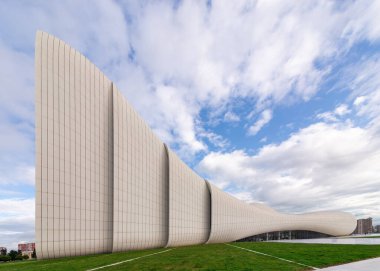 Azerbaycan 'ın Bakü kentindeki Heydar Aliyev Merkezi, akış çizgileri ve fütüristik tasarımı ile dikkat çekiyor. Bu dönüm noktası, Mimar Zaha Hadid 'in açık mavi gökyüzüne karşı yenilikçi tarzını yansıtır.